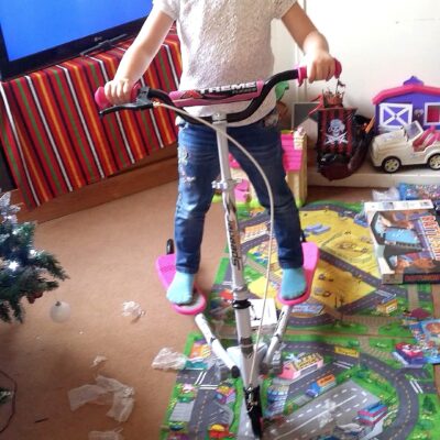 December 2015, photo of Gabrielle Abreu in the living room, standing on a white & pink tri-scooter daddy gifted to her at christmas. This photo is part of a group that will help provide some perspective to layout & dimensions for their living room. This photo faces fireplace wall of the living room. Click on it to expand.