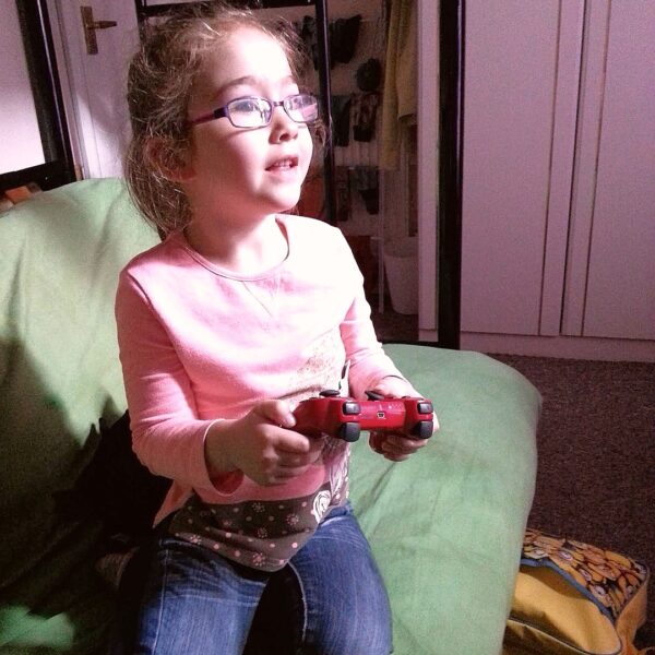 April 2015, photo of Gabrielle Abreu playing on daddy's PS3 whilst sitting on the bellow bed futon, in daddy's bedroom. This photo is part of a group that will help provide some perspective to layout & dimensions for the bedroom. This photo is facing the bedroom door & fitted wardrobe. Click on it to expand.